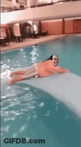 A Man Is Floating On A Raft In A Pool GIF