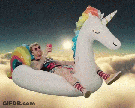 A Man Is Floating On An Inflatable Unicorn GIF