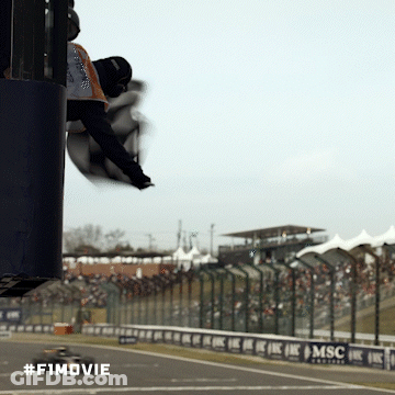 A Man Is Flying Through The Air At A Race Track With The #F1movie Written On The Bottom GIF