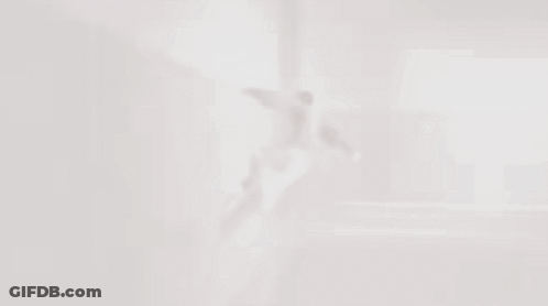 A Man Is Flying Through The Air In A Room GIF