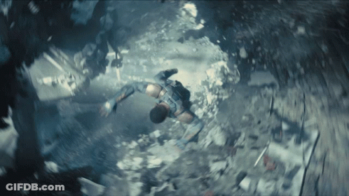 A Man Is Flying Through The Air In A Very Dark Room GIF