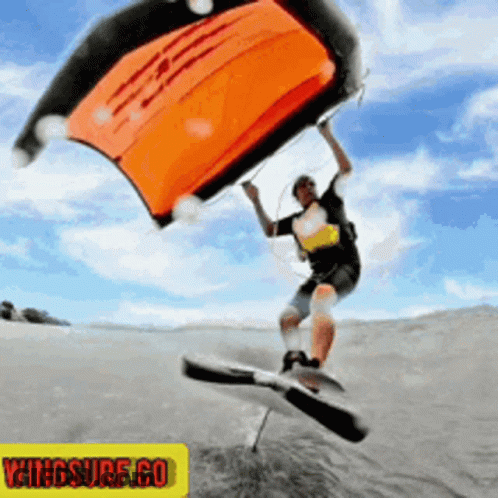 A Man Is Flying Through The Air With A Wingsurf.co Logo In The Background GIF
