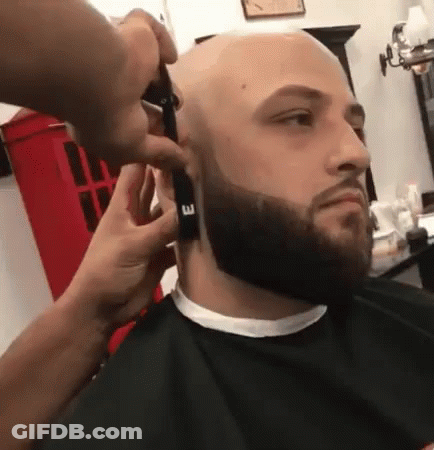 A Man Is Getting His Beard Trimmed By A Barber GIF