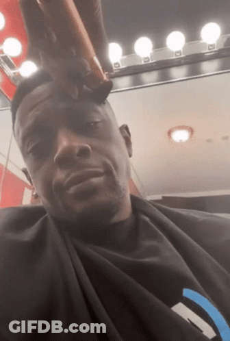 A Man Is Getting His Hair Cut By A Barber GIF