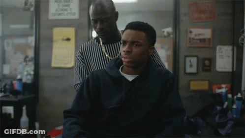 A Man Is Getting His Hair Cut By A Barber In Front Of A Sign That Says " No Smoking " GIF