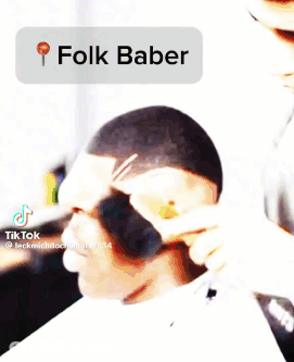 A Man Is Getting His Hair Cut By A Barber Using A Folk Baber . GIF