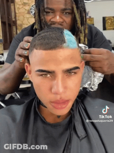 A Man Is Getting His Hair Cut By A Man With Dreadlocks And A Tik Tok Sticker GIF