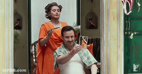 A Man Is Getting His Hair Cut By A Woman With Curlers In His Hair GIF