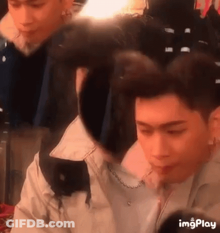 A Man Is Getting His Hair Done In A Salon While A Woman Looks On . GIF
