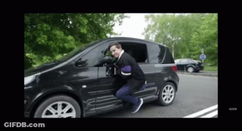 A Man Is Getting Out Of A Black Car With A Stop Sign In The Background GIF