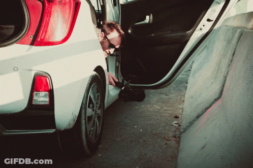A Man Is Getting Out Of A White Car With The Door Open GIF