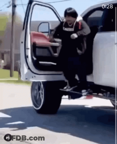 A Man Is Getting Out Of A White Truck With A Skateboard Attached To The Back Of It . GIF