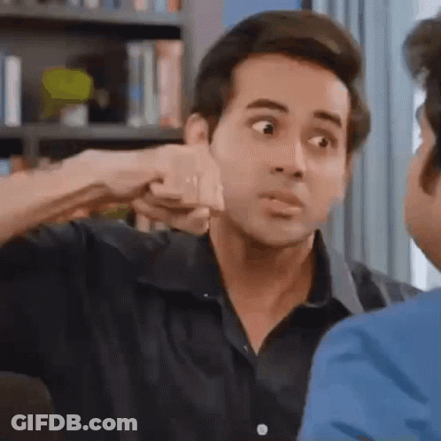 A Man Is Giving A Fist Bump To Another Man In A Living Room . GIF