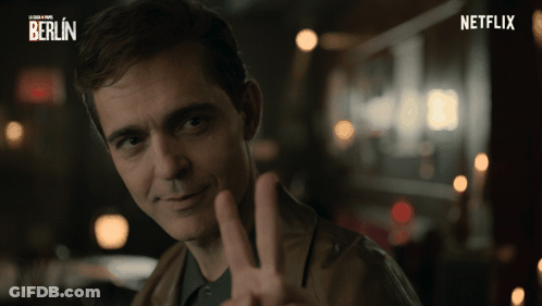A Man Is Giving A Peace Sign In Front Of A Netflix Logo GIF