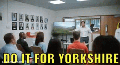 A Man Is Giving A Presentation In Front Of A Group Of People In A Room . GIF