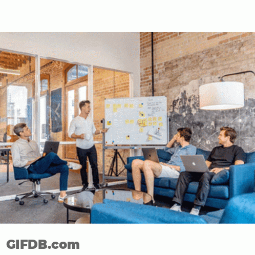 A Man Is Giving A Presentation To A Group Of People Sitting On A Couch GIF