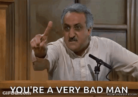 A Man Is Giving A Speech At A Podium And Pointing At The Audience . GIF