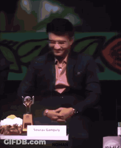 A Man Is Giving A Speech At A Podium And The Word Noman Is On The Screen Behind Him GIF