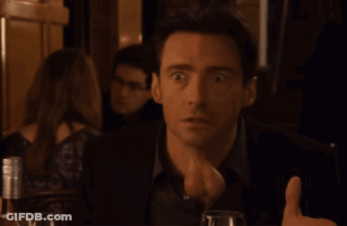 A Man Is Giving A Thumbs Up In A Dark Room GIF