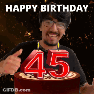 A Man Is Giving A Thumbs Up In Front Of A Cake With Candles That Say 45 GIF