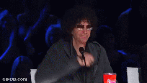 A Man Is Giving A Thumbs Up In Front Of A Microphone GIF