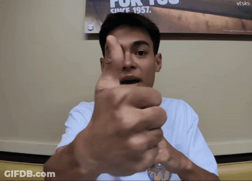 A Man Is Giving A Thumbs Up In Front Of A Poster That Says For You Since 1957 GIF