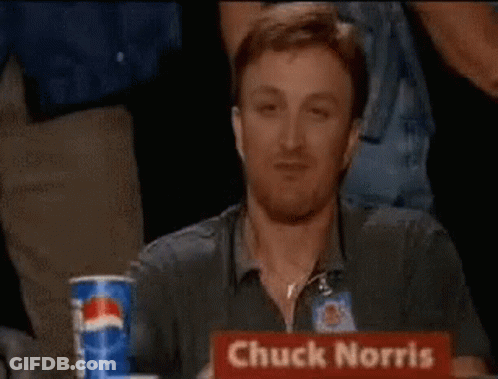 A Man Is Giving A Thumbs Up With The Words Chuck Norris Approves Behind Him . GIF