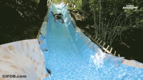 A Man Is Going Down A Water Slide That Says Waterslide Awesome GIF