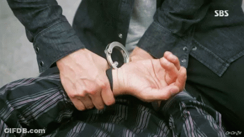A Man Is Handcuffed To Another Man 'S Wrist In A Sbs Show . GIF