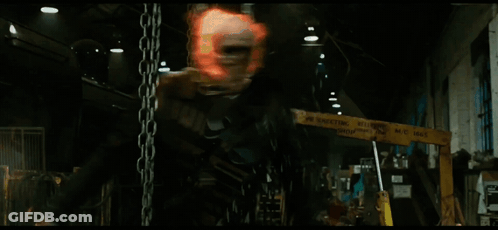 A Man Is Hanging From Chains In A Dark Room GIF
