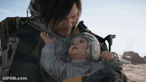 A Man Is Holding A Baby In His Arms And The Baby Is Wearing A Jacket With The Number 13 On The Front GIF