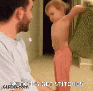 A Man Is Holding A Baby In His Arms While The Baby Is Standing In Front Of Him . GIF
