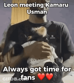A Man Is Holding A Baby In His Arms With A Caption That Says Leon Meeting Kamaru Usman Always Got Time For Fans GIF