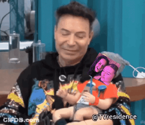 A Man Is Holding A Baby In His Arms With A Picture Of A Woman Behind Him And The Hashtag Tvresidence GIF