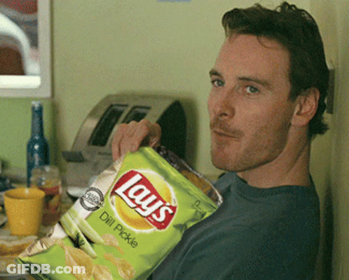 A Man Is Holding A Bag Of Lays Chips GIF