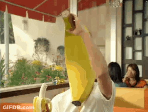 A Man Is Holding A Banana Over His Head GIF