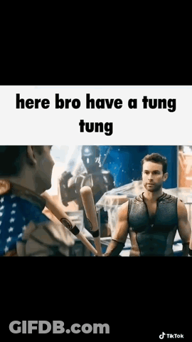 A Man Is Holding A Baseball Bat And Talking To Another Man In A Boxing Ring . GIF