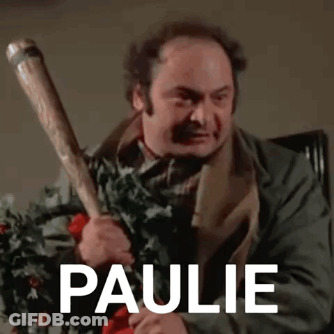 A Man Is Holding A Baseball Bat In His Hand With The Name Paulie Written On It . GIF