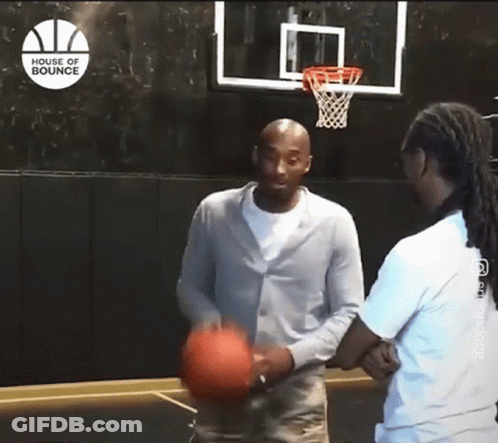 A Man Is Holding A Basketball In Front Of A Basketball Hoop That Says House Of Bounce GIF