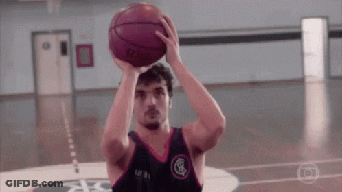 A Man Is Holding A Basketball Over His Head While Playing Basketball On A Court . GIF