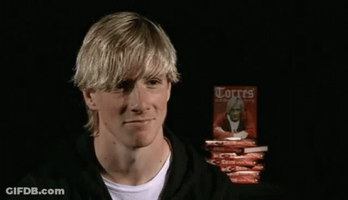 A Man Is Holding A Book Titled Torres GIF