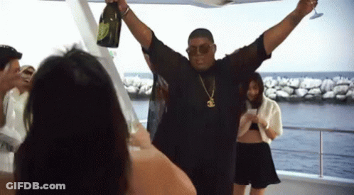 A Man Is Holding A Bottle Of Champagne And A Glass GIF