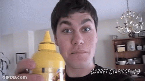 A Man Is Holding A Bottle Of Garret Claridge 10 Mustard GIF