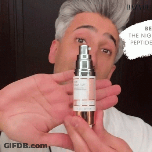 A Man Is Holding A Bottle Of Night Peptide Serum GIF