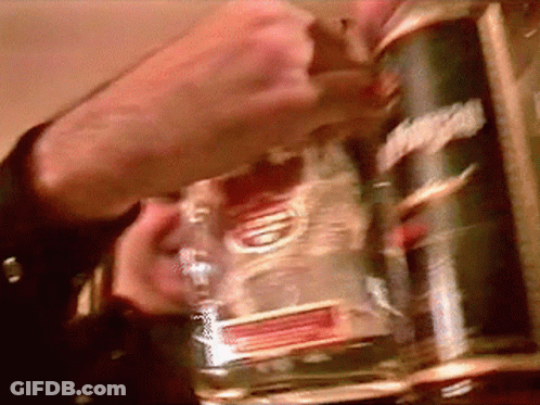 A Man Is Holding A Bottle Of Smirnoff Vodka In His Hand GIF
