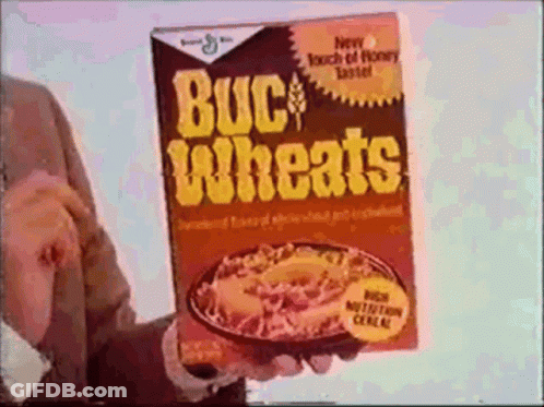 A Man Is Holding A Box Of Buckwheats Cereal In His Hand GIF