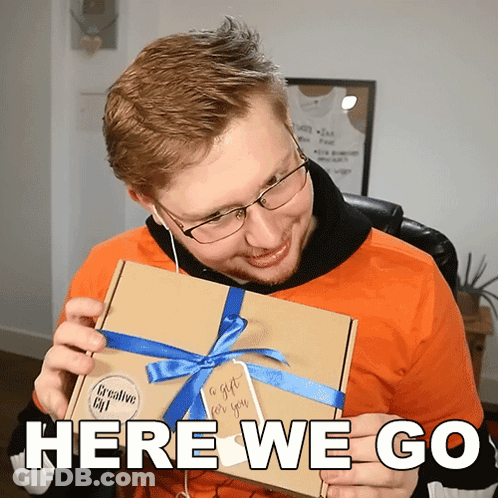 A Man Is Holding A Box With A Blue Ribbon And Says Here We Go GIF