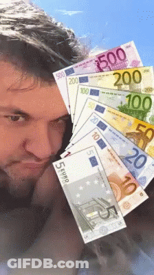 A Man Is Holding A Bunch Of Euro Bills In Front Of His Head GIF