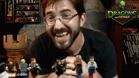 A Man Is Holding A Bunch Of Lego Figures In Front Of A Dragon And Things Sign GIF