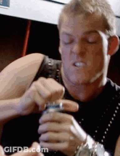 A Man Is Holding A Can Of Soda In His Hand And Making A Face . GIF